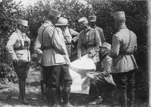 The King of Romania and General Averescu with officers examining a military map outdoors