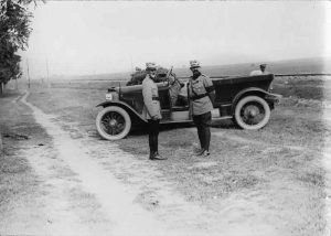 The King of Romania and General Averescu in military uniforms, standing next to an automobile