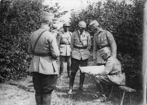 The King of Romania and General Averescu with officers examining a military map outdoors