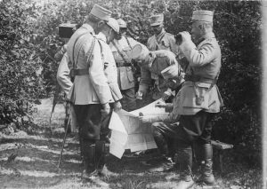 The King of Romania, General Averescu, and officers studying a military map outdoors