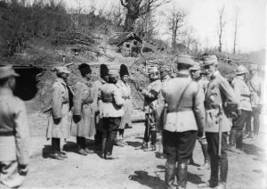 King Ferdinand and General Averescu with officers and soldiers at the front, before shelters dug into the hillside