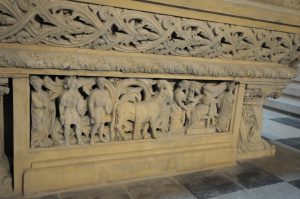 Stone bas-relief at Mărăști Mausoleum depicting sculpted human figures and an animal beneath an ornate frieze