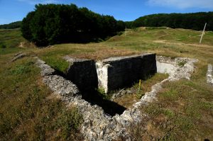 Stone and concrete ruins of the water catchment basin at Mărăști on a grassy hill