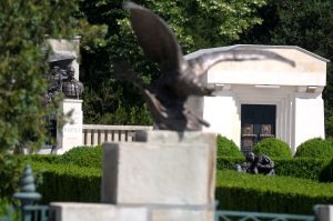 Partial view of Mărăști Mausoleum with bronze statues, eagle sculpture in foreground and greenery