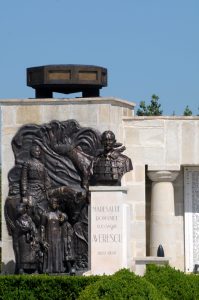Bronze bust of Marshal Alexandru Averescu on a stone pedestal next to the bas-relief of Mărăști Mausoleum