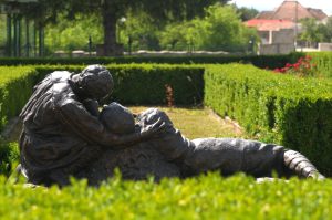 Bronze sculpture by Aurel Bordenache in the park of Mărăști Mausoleum, surrounded by hedges