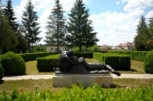 Bronze sculptural group by Aurel Bordenache in the park of the Mărăști Mausoleum, surrounded by hedges and firs