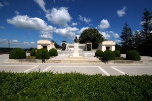 Bust of Marshal Averescu on a white pedestal in front of the Mărăști Mausoleum, with paved alleys and greenery