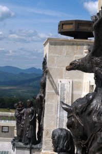 Detail of the bronze bas-relief at the Mărăști Mausoleum, eagle sculpture, and mountain landscape