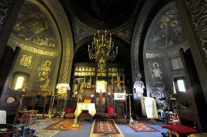 Interior of Maria Magdalena Church with wooden iconostasis, chandelier, and wall frescoes