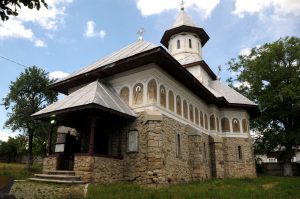Church in Mărăști built of river stone, with external saint paintings under the eaves and sheet metal roof