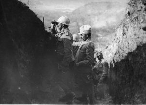 Officers in a trench observing the battlefield through binoculars