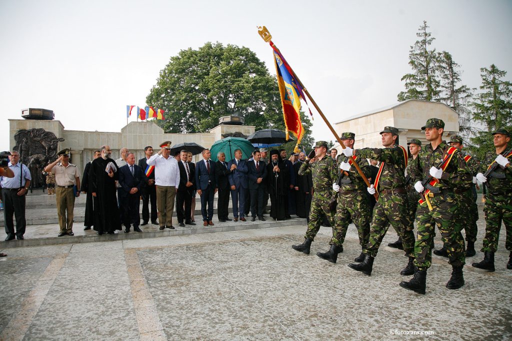 Romanian soldiers marching with the battle flag in front of officials at the Mărăști Mausoleum