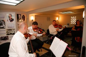 Musicians playing violins and cello in a room of the Mărăști Mausoleum