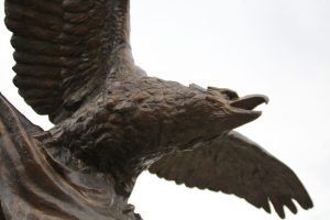 Detail of a bronze eagle with outstretched wings and open beak on a monument